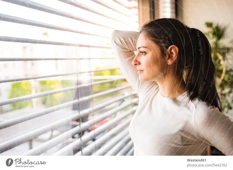 Woman at home looking out of the window watching windows woman females women view seeing viewing Adults grown-ups grownups adult people persons human being