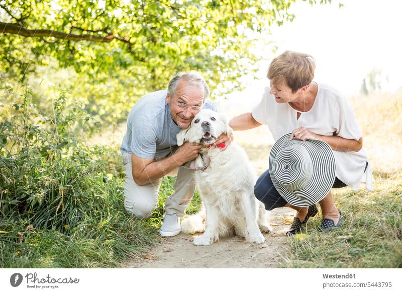 Senior couple petting dog outdoors smiling smile dogs Canine twosomes partnership couples pets animal creatures animals people persons human being humans