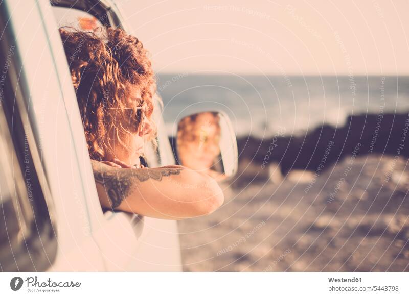 Tatooed woman looking out of a car females women Adults grown-ups grownups adult people persons human being humans human beings vacation holidays vacations