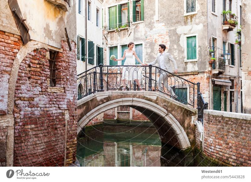 Italy, Venice, bridal couple running on little bridge bridal couples married couple married couples marriage people persons human being humans human beings