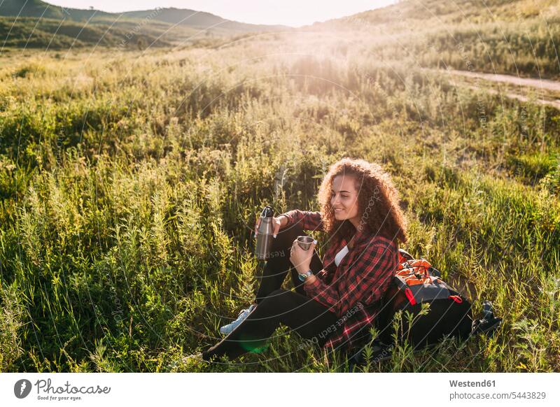 Teenage girl with thermos flask having a rest in nature resting Teenage Girls female teenagers Teenager Teens people persons human being humans human beings