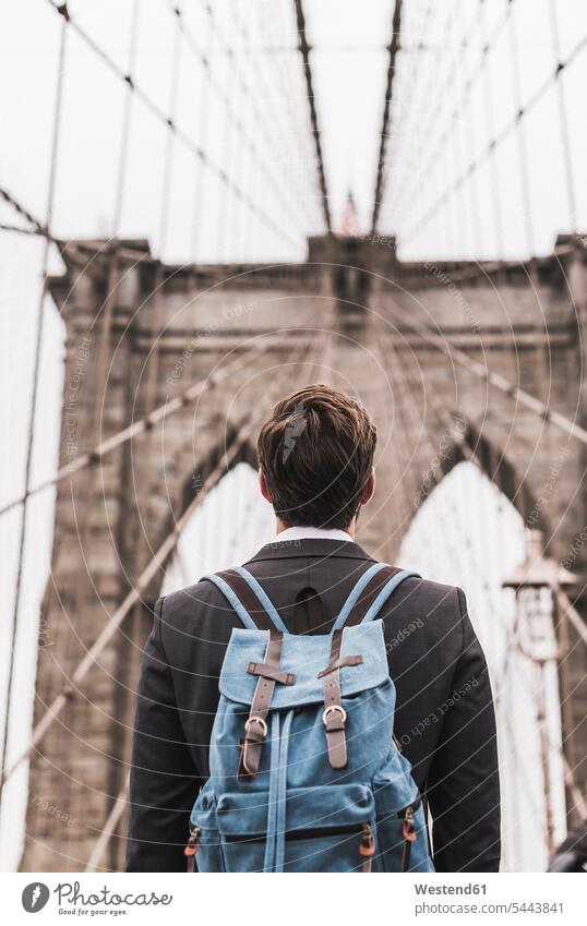 USA, New York City, man with backpack on Brooklyn Bridge rucksacks backpacks back-packs bridge bridges men males New York State transportation Adults grown-ups