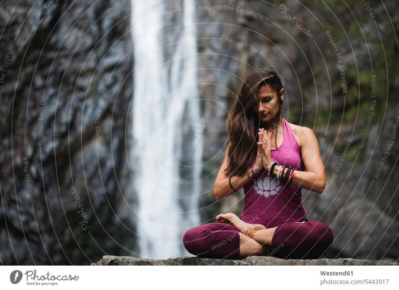 Italy, Lecco, woman doing meditation near a waterfall waterfalls sitting Seated meditating meditations yoga females women waters body of water meditate
