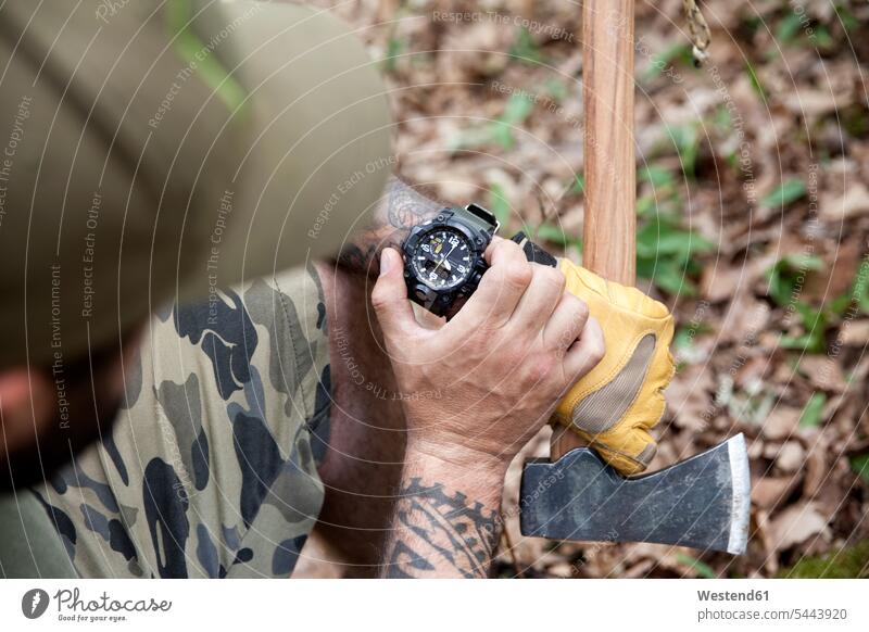 Close-up of man with axe in forest checking the time woods forests wrist watch Wristwatch Wristwatches wrist watches tattoo tattoos men males tattooed style