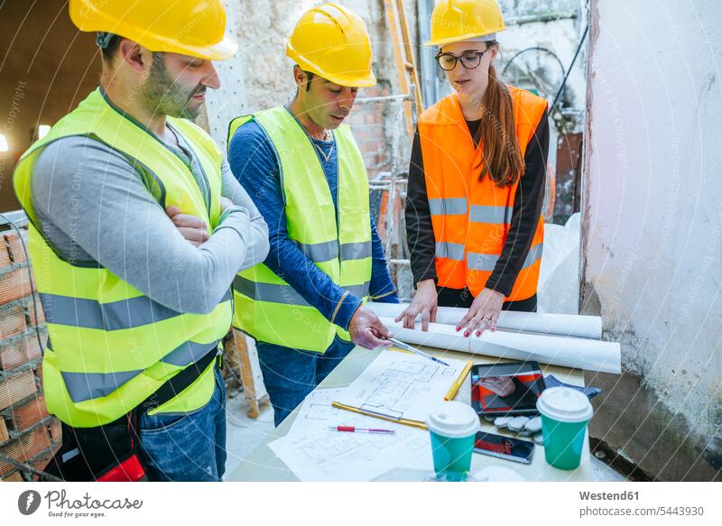 Woman and two construction workers talking on construction site colleagues Building Site sites Building Sites construction sites builders constructing craftsman