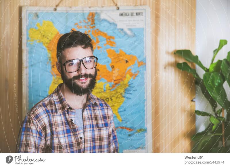 Portrait of bearded man wearing glasses in front of a map men males portrait portraits Adults grown-ups grownups adult people persons human being humans