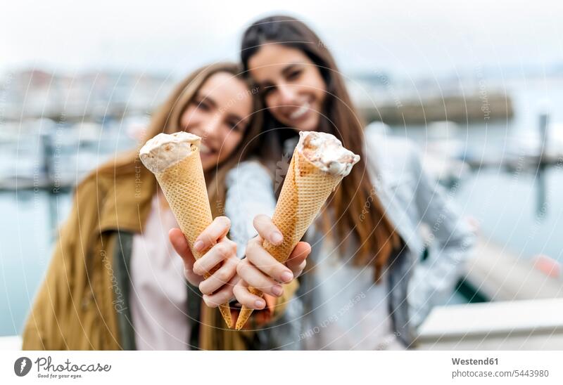 Two young women having fun with icecream holding Fun funny female friends Sweet Food sweet foods food and drink Nutrition Alimentation Food and Drinks mate