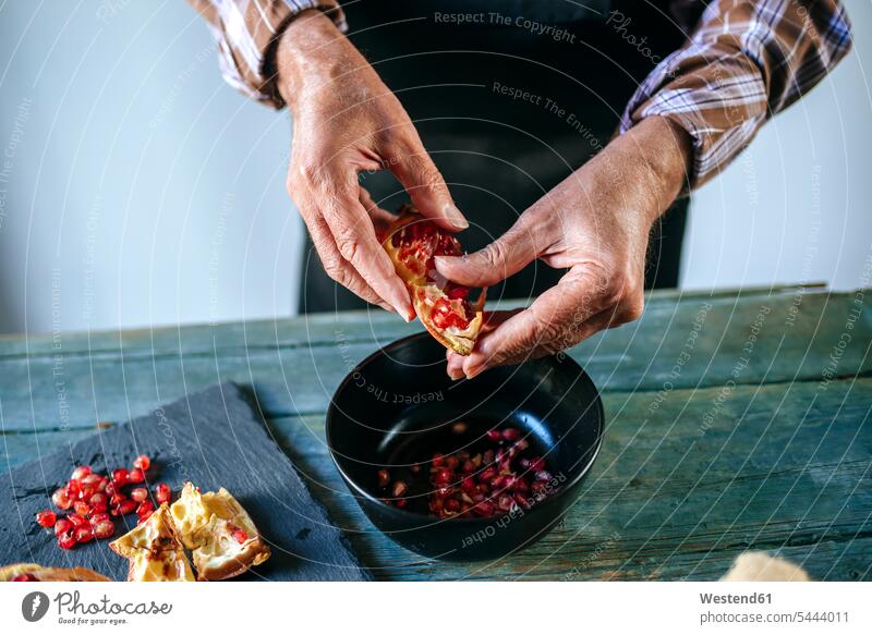 Man's hands peeling a pomegranate pare paring Pomegranate Pomegranates man men males human hand human hands Tropical Fruit tropical fruits Tropical Fruits Food