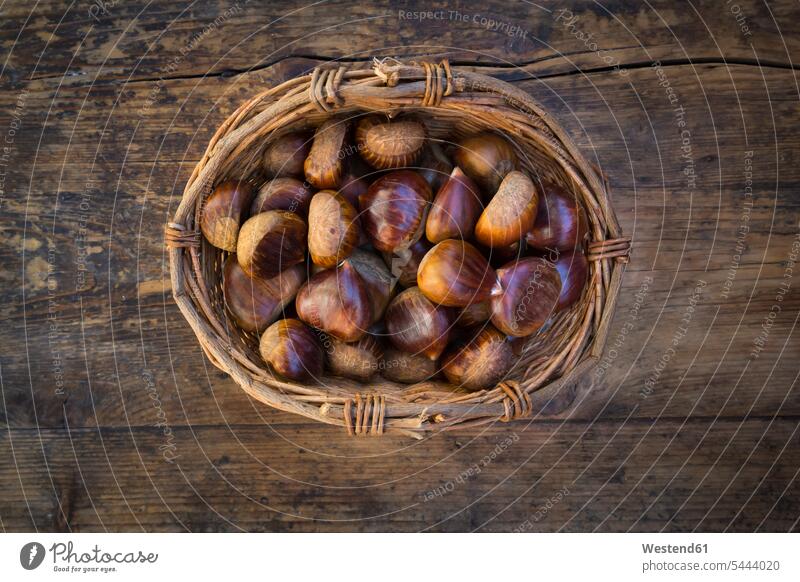 Roasted sweet chestnuts in a basket nobody baskets dark large group of objects many objects copy space wooden Chestnut Chestnuts Aesculus hippocastanum