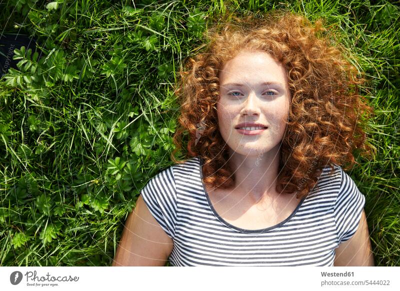 Portrait of smiling young woman lying on a meadow meadows females women portrait portraits Adults grown-ups grownups adult people persons human being humans