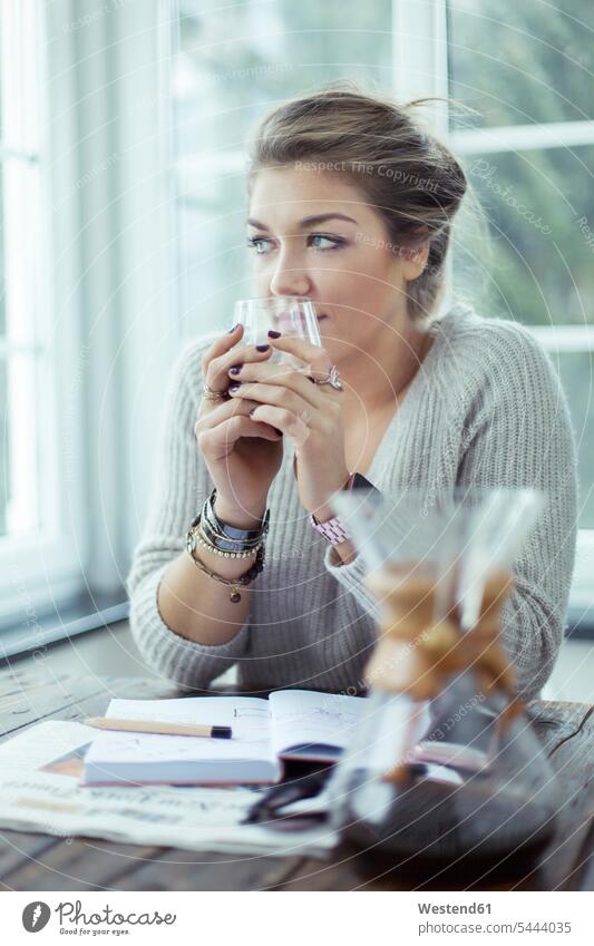 Portrait of young woman with glass of coffee looking through window portrait portraits females women Adults grown-ups grownups adult people persons human being