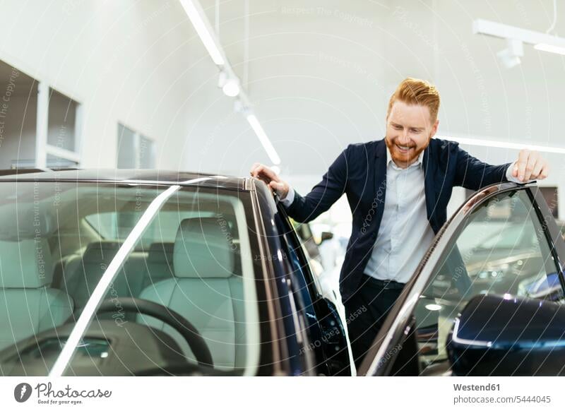 Customer looking at car in car dealership customer clientele clients customers choosing select choose selecting automobile Auto cars motorcars Automobiles