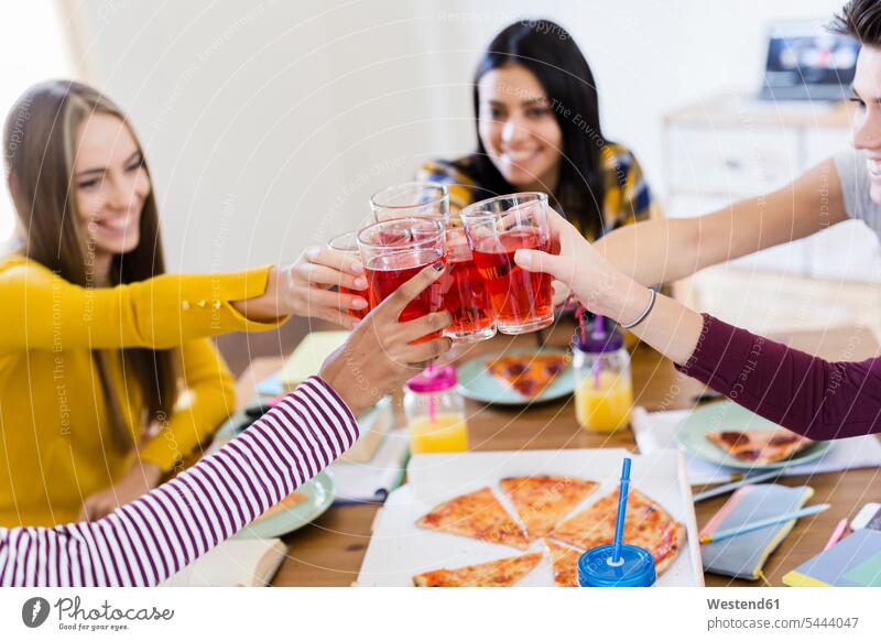 Group of young women at home clinking glasses studying woman females Pizza Pizzas Glass Drinking Glasses student female students toasting cheers sharing share