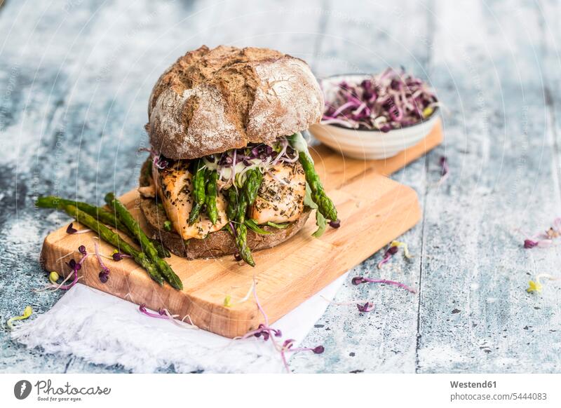 Salmon burger with green asparagus and red cress on chopping board nobody cresses crisp crunchy ready to eat ready-to-eat sandwich open-faced sandwich
