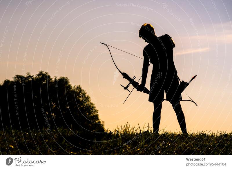 Silhouette of an archeress at twilight woman females women archery arrow arrows Adults grown-ups grownups adult people persons human being humans human beings