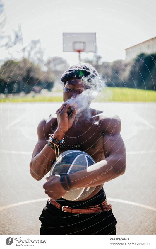 Barechested basketball player on court smoking a joint man men males basketballs basketball players smoke Adults grown-ups grownups adult people persons