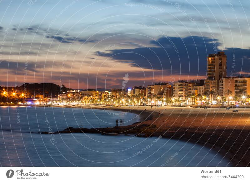 Spain, Catalonia, Lloret de Mar, resort town on Costa Brava, beach and skyline at twilight illuminated lit lighted Illuminating bay Bay Of Water bays