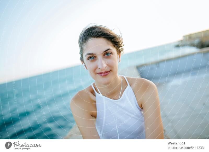 Portrait of young woman at the coast sea ocean sitting Seated females women water waters body of water Adults grown-ups grownups adult people persons