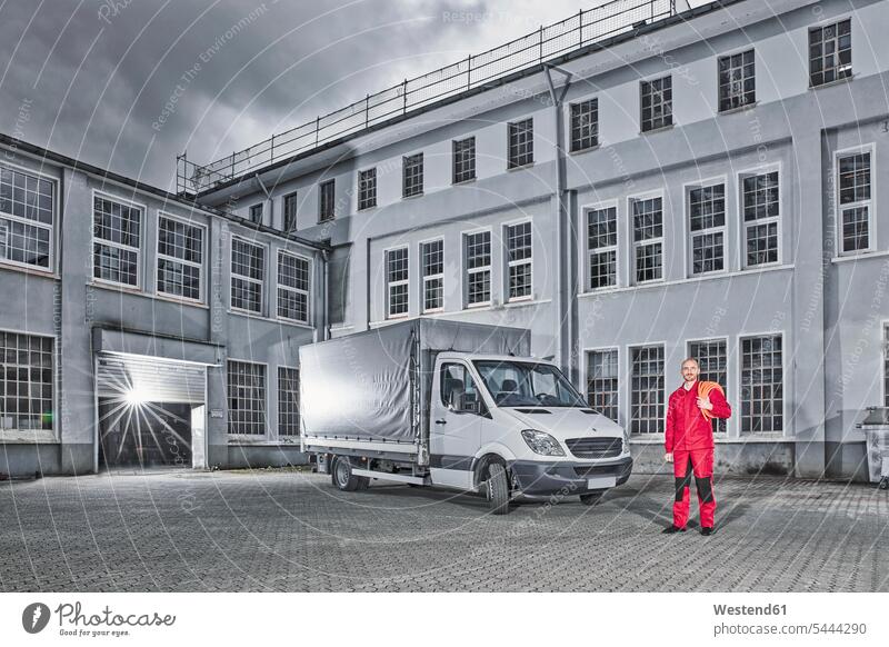 Man standing next to delivery van on yard of a building pick-up truck Cargo Vans motor vehicle road vehicle road vehicles motor vehicles transportation toned