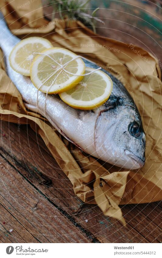 Sea Bream on a baking paper with lemon sea bream sea breams wrapped Wrapped Up wooden raw fish food fish edible fish preparing Food Preparation preparing food