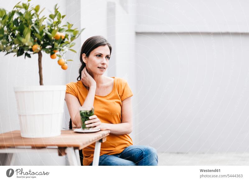 Woman relaxing next to orange tree sitting Seated woman females women portrait portraits smiling smile Adults grown-ups grownups adult people persons