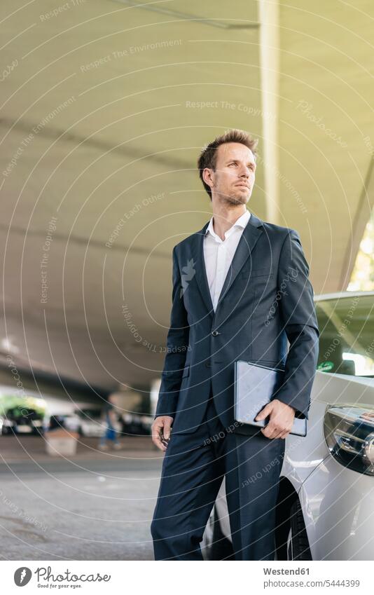 Businessman standing next to car holding laptop Laptop Computers laptops notebook Business man Businessmen Business men computer computers business people