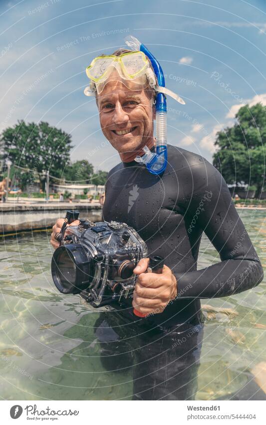 Portrait of happy man with underwater DSLR camera case in a lake cameras diving dive men males smiling smile diver divers Adults grown-ups grownups adult people