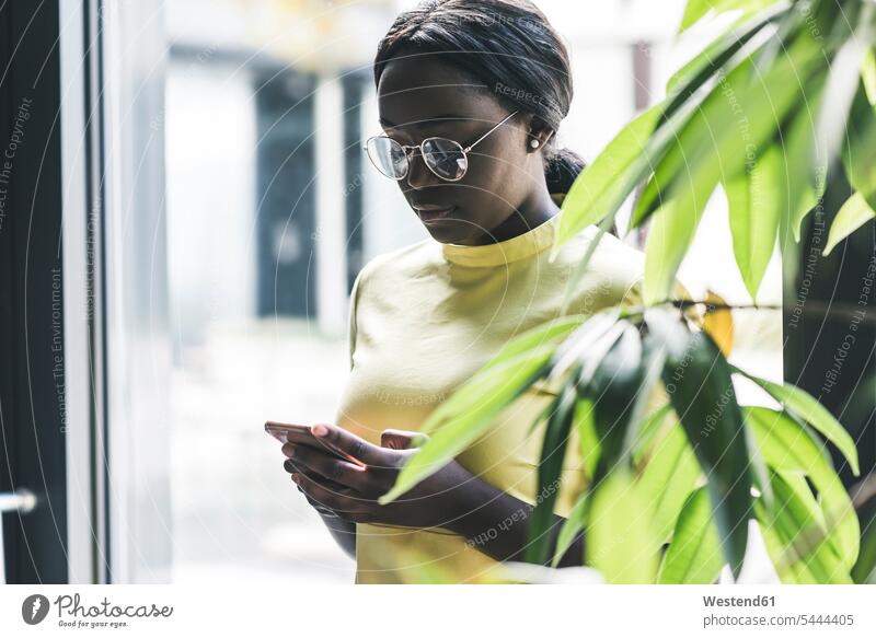 Businesswoman looking at cell phone Smartphone iPhone Smartphones mobile phone mobiles mobile phones Cellphone cell phones businesswoman businesswomen