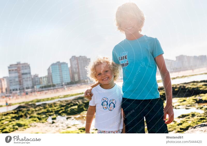Portrait of two happy brothers on the beach boy boys males siblings brother and sister brothers and sisters family families people persons human being humans