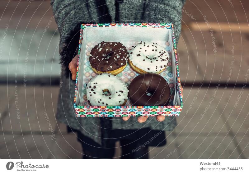 Woman holding box with doughnuts, partial view donuts Doughnuts cardboard box Cardboard Carton carton cardboard boxes Cardboards cartons Pastry Pastries
