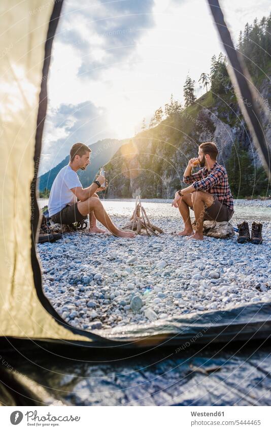 Germany, Bavaria, two hikers camping on gravel bank in the evening friends friendship trekking tent tents sitting Seated nature experience relaxation relaxing