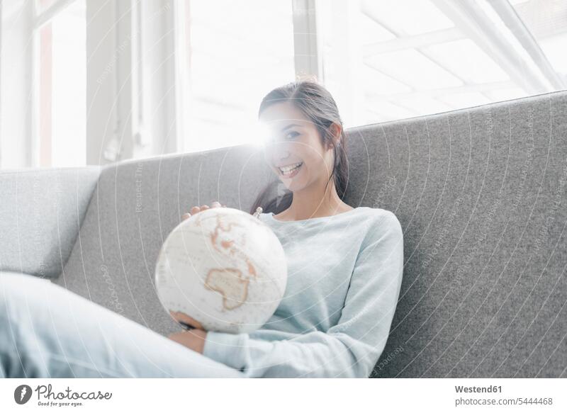 Young woman holding globe, planning world trip vacation Holidays females women Travel international globes loft lofts young Adults grown-ups grownups adult