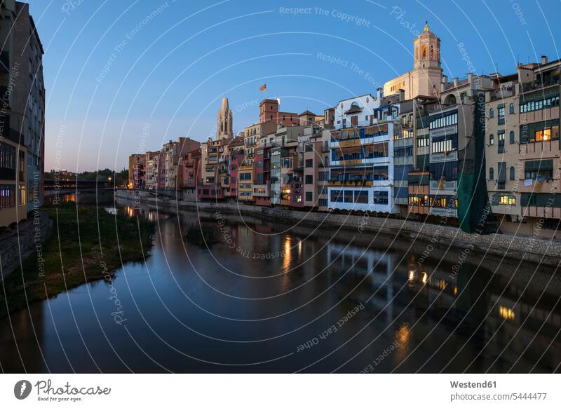 Spain, Girona, Basilica of San Felix and Cathedral of Santa Maria behind houses at Onyar River in the evening Barri Vell Architecture urban scene Gerona