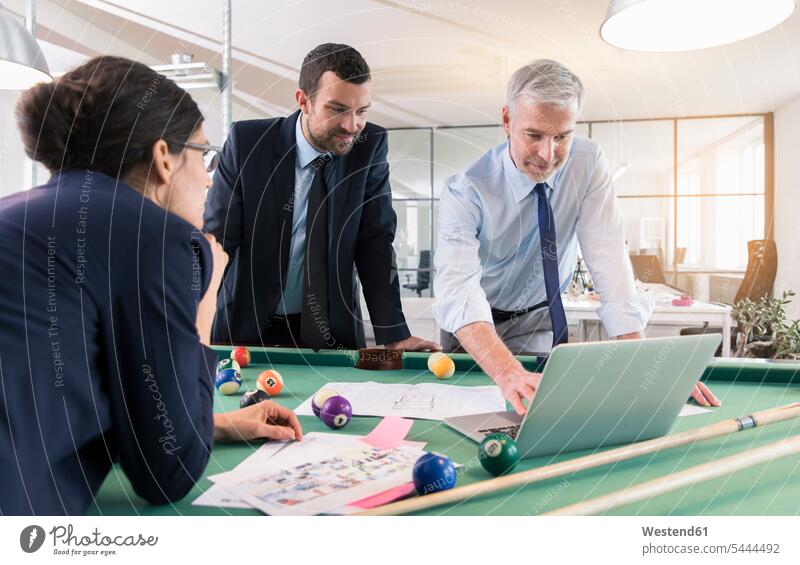 Business people standing at pool table with laptop, discussing investment strategy strategic Strategies billiard table billiard tables business people