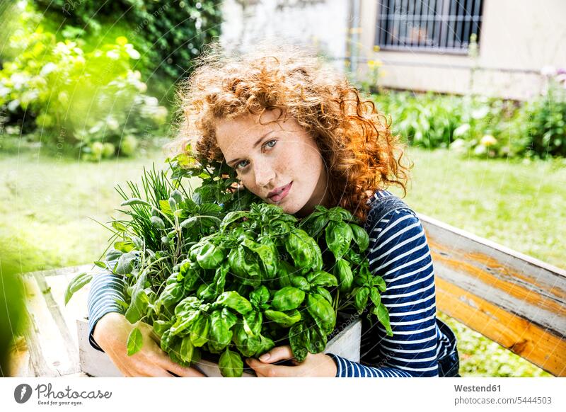 Portrait of young woman with fresh herbs in a box portrait portraits garden gardens domestic garden females women spice flavouring flavoring spices Food foods
