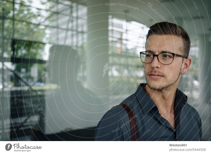 Portrait of pensive young businessman wearing glasses Businessman Business man Businessmen Business men specs Eye Glasses spectacles Eyeglasses thoughtful