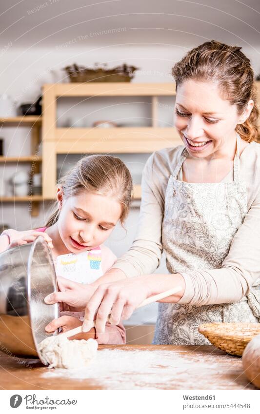 Mother and daughter baking in kitchen together mother mommy mothers ma mummy mama domestic kitchen kitchens daughters smiling smile bake parents family families