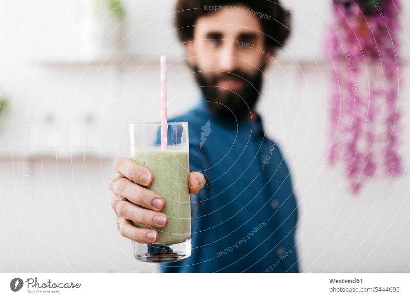 Man's hand holding glass of green smoothie, close-up human hand hands human hands Smoothies people persons human being humans human beings Drink beverages