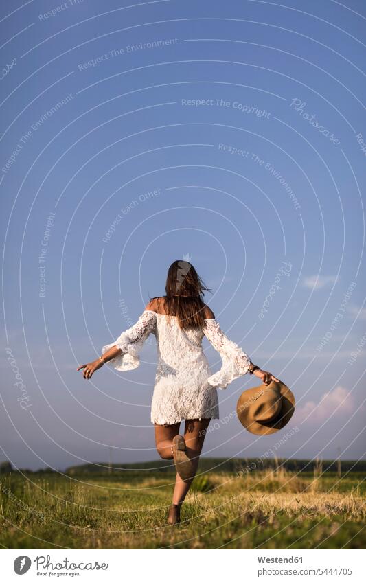Happy woman in a field Field Fields farmland females women happiness happy hat hats Adults grown-ups grownups adult people persons human being humans
