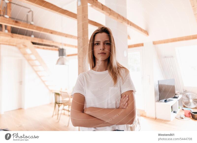 Confident young woman standing in her apartment with arms crossed cozy sociable comfortable cosy home ownership private owned home loft lofts Arms Folded