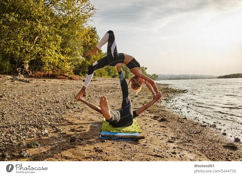 Young man and woman practicing Acro Yoga back bend back bending exercise exercises practising exercising acrobatics Acrobatic Activity balancing balance River