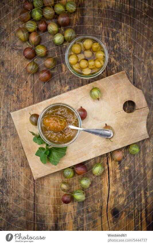 Jar of gooseberry jam, gooseberries and glass of preseved gooseberries on wood Spoon Spoons rustic large group of objects many objects uncooked fruit homemade