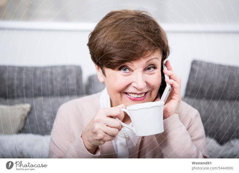 Portrait of a senior woman using smart phone, drinking coffee females women mobile phone mobiles mobile phones Cellphone cell phone cell phones Smartphone