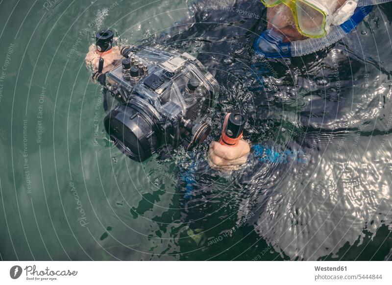 Man with underwater DSLR camera case in a lake cameras diving dive man men males diver divers Adults grown-ups grownups adult people persons human being humans