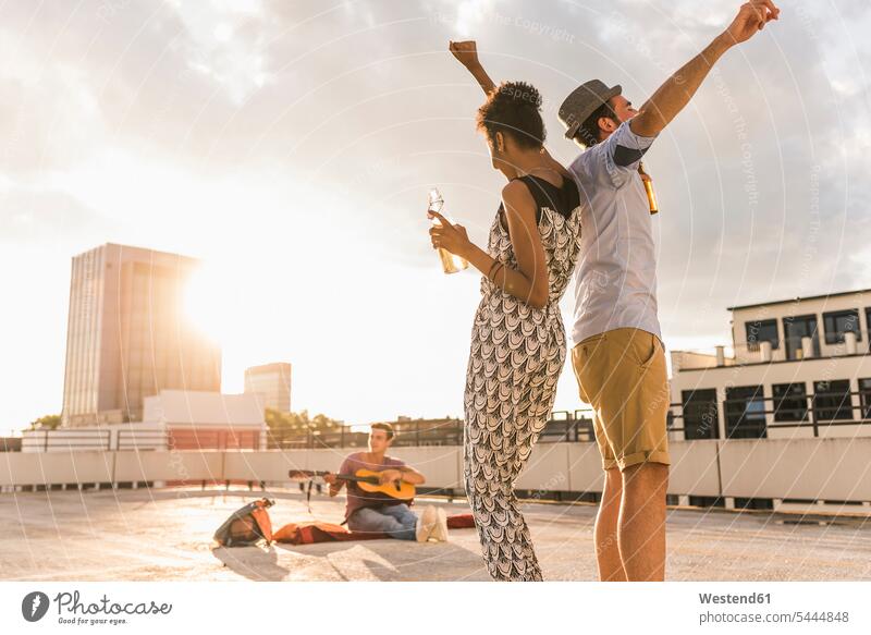 Young couple dancing on a rooftop party roof terrace deck friends Beer Beers Ale drinking dance Fun having fun funny celebrating celebrate partying Party