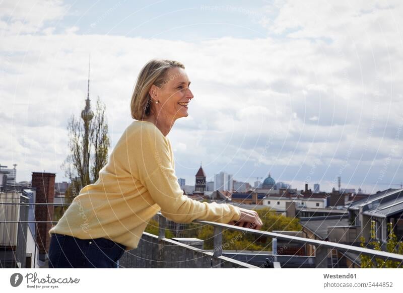 Smiling mature woman on balcony looking at view balconies View Vista Look-Out outlook smiling smile females women Adults grown-ups grownups adult people persons