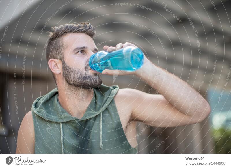 Athlete taking a break in the city drinking water from bottle exercising exercise training practising man men males Water Adults grown-ups grownups adult people