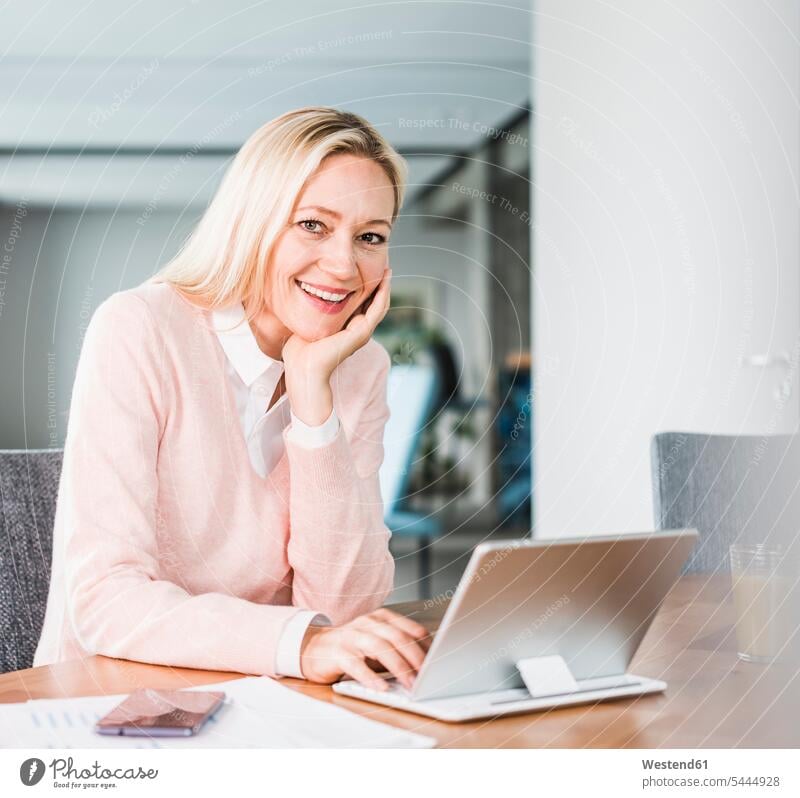 Portrait of smiling businesswoman using tablet in office businesswomen business woman business women smile portrait portraits working At Work digitizer