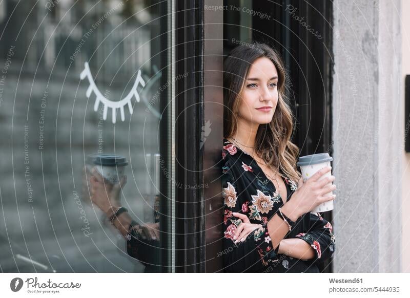 Portrait of fashionable woman with coffee to go leaning at entrance door of her shop portrait portraits Coffee to Go takeaway coffee entry door entrance doors