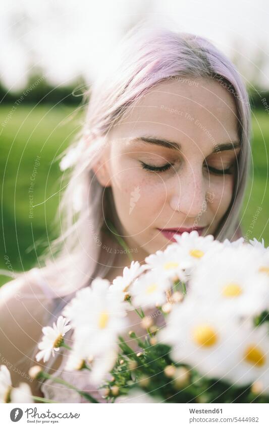 Woman with eyes closed holding bunch of daisies portrait portraits woman females women Adults grown-ups grownups adult people persons human being humans